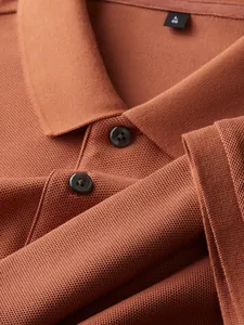 Close-up of terracotta cotton Polo shirt showing collar detail and fabric texture.
