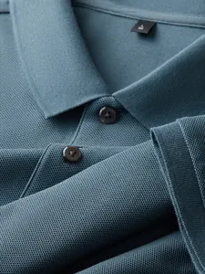 Close-up of teal blue 100% cotton pique polo shirt collar and buttons