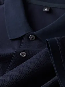 Detailed close-up view of navy blue cotton polo shirt showing fabric texture and collar