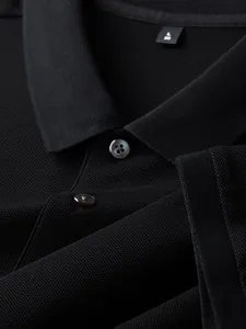 Close-up detail of black cotton polo shirt collar and buttons with pique texture