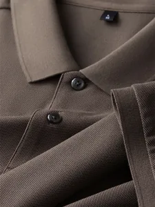 Close-up detail of a brown 100% cotton polo shirt collar and high-quality piqué fabric