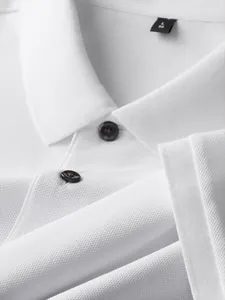 Close-up macro view of a white 100% cotton pique polo shirt collar and dark buttons