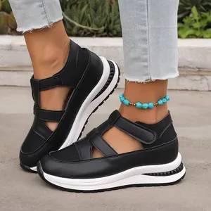 Detailed view of black breathable platform sandals with velcro straps on model.