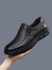 Detail of black men's genuine leather loafers showing textured cowhide and slip-on design