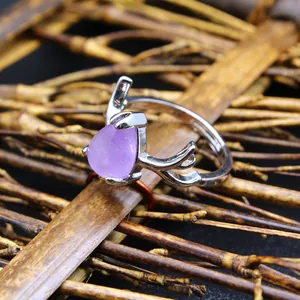 Close-up of silver antler ring with purple teardrop crystal on bamboo background