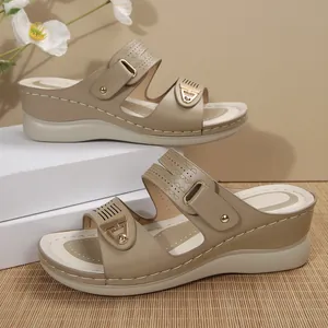 Detail view of comfortable khaki wedge sandals with gold metal buckles and stitching