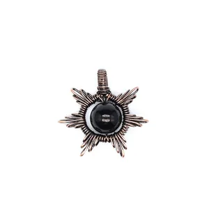 Detail view of handmade wire-wrapped sun pendant with a polished black natural stone