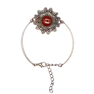 Detailaufnahme eines Vintage-Bronze-Blumenarmbands mit rotem Stein und verstellbarer Kette