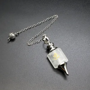 Detailed close-up of a white quartz crystal pendulum with golden Om symbol engraving