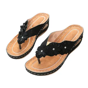 Tongs compensées noires pour femmes avec fleurs décoratives et strass étincelants