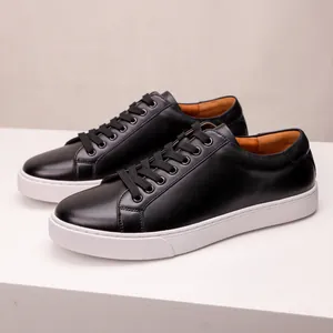 Detailed close-up of premium black leather men's sneakers featuring a white thick sole design