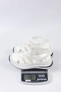 White platform wedge sandals for women shown being weighed on a scale at 430.1 grams