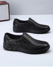 Detailed texture of black genuine leather men's loafers with slip-on design.