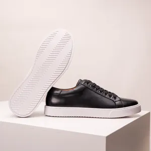 Detailed side and sole view of black leather sneakers with thick white soles.