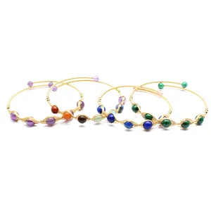 Dettaglio di braccialetti fatti a mano in filo d'oro 14K con varie pietre naturali