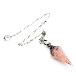 Detail view of a rose quartz resin pendulum with a hexagonal cone and metal coil