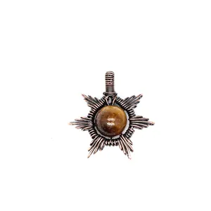Detailed view of hand-woven copper wire sun pendant with natural tiger's eye stone