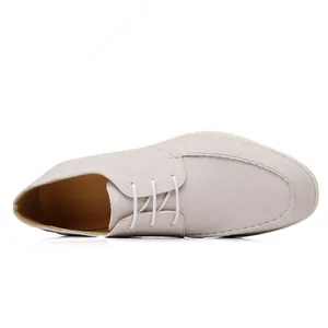 Detailed top-down view of a light gray suede lace-up casual shoe featuring a clean white sole.