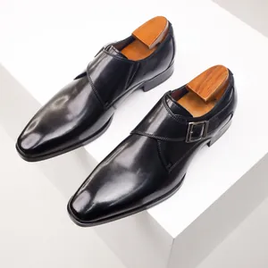 Detailed view of polished black leather monk strap shoes with wooden shoe trees.