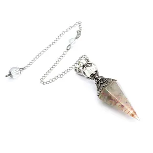 Detail of hexagonal cone crystal dowsing pendulum with resin-embedded garnet stones