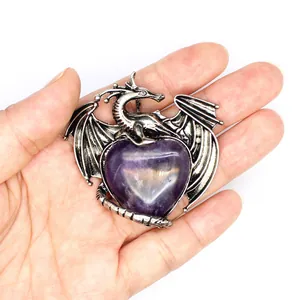 Detailaufnahme eines Drachen-Herz-Anhängers aus Amethyst, der in der Hand liegt