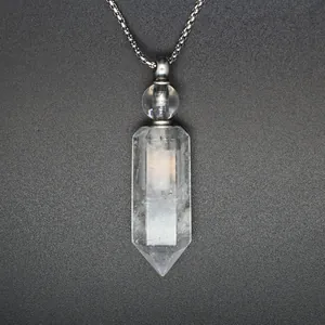 Detailed macro view of a clear hexagonal crystal perfume bottle pendant on a silver chain