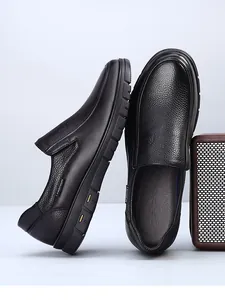 Close-up of black cowhide leather men's slip-on loafers with lychee grain texture.