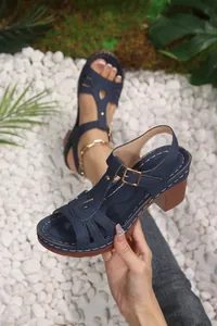 Detail view of navy blue T-strap sandals with chunky wood-effect heel