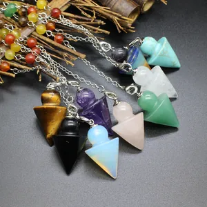 Close-up detail of chakra crystal pendulums with various natural gemstones and chains