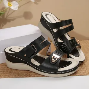 Stylish black wedge sandals for women with thick soles and gold metal buckles.