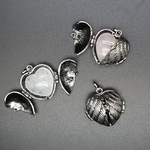 Close-up of heart locket pendants with angel wings showing open and closed views