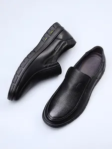 Detailed macro view of black genuine cowhide leather loafers with fine lychee texture