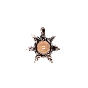 Close-up of a handcrafted sunstone pendant featuring intricate copper wire-wrapped detail.