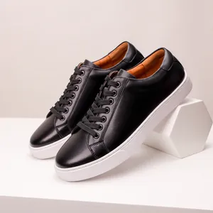 Detailed view of men's black leather casual shoes with thick white soles and black laces.