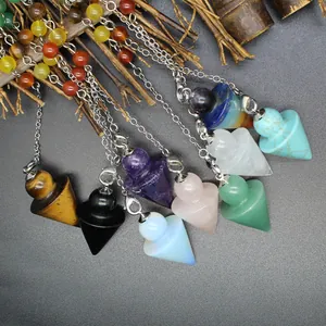 Detailed view of colorful arrow-shaped crystal dowsing pendulums with silver chains.