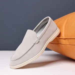Detailed view of a light grey suede loafer for men featuring classic hand-stitched detailing