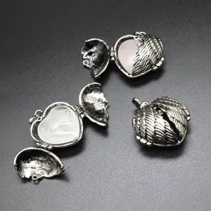 Detail showing openable vintage angel wing heart locket with natural stone.