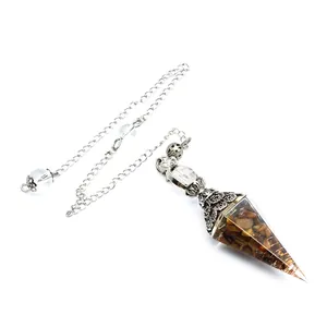 Close-up detail of a hexagonal resin pendulum filled with natural tiger's eye stone chips