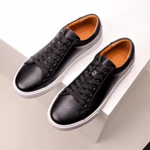 Detail view of premium black leather men's sneakers with contrasting white soles
