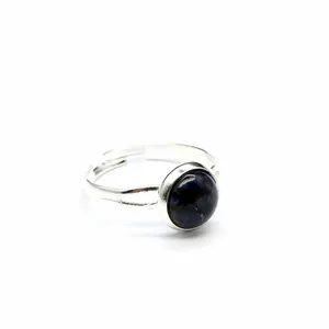 Vista dettagliata di un anello in argento regolabile con una pietra naturale blu scuro.