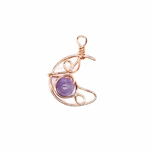 Macro detail of handmade wire wrapped crescent moon pendant with amethyst stone