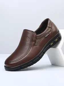 Macro detail view of premium brown pebbled leather loafers featuring a slip-on design.