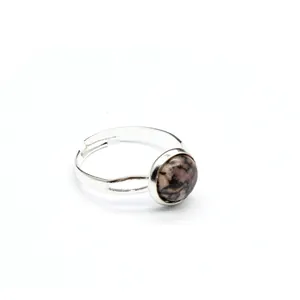Dettaglio di un anello regolabile in argento con intarsio tondo in rodonite rosa.