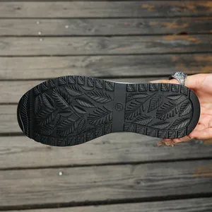 Detailed view of the black rubber sole featuring leaf-patterned anti-slip tread design