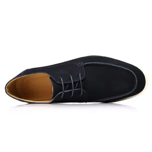 Top-down close-up view of a navy blue suede casual lace-up derby shoe with a white sole