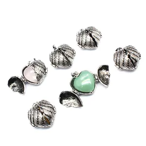 Detailed view of antique silver openable angel wing heart pendant with natural stones