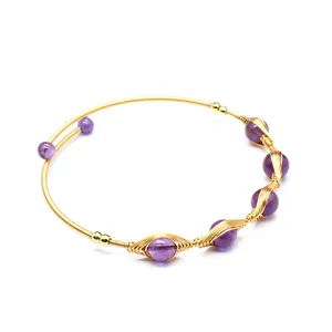 Dettaglio di bracciale artigianale in filo d'oro 14K con perle di ametista viola