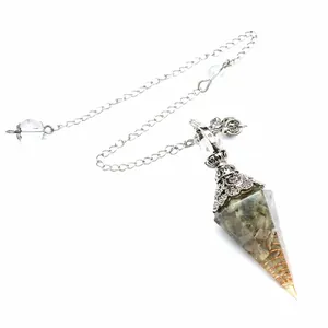 Detail of hexagonal resin dowsing pendulum with labradorite stones and copper wire coil.
