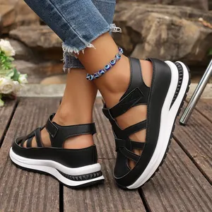 Close-up of black platform wedge sandals with hollow out design and velcro strap