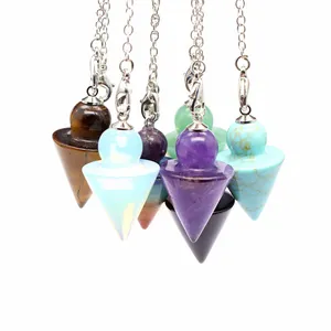 Close-up of colorful chakra crystal dowsing pendulums in cone arrow shape